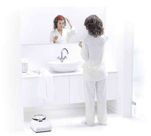 Balanza mecánica Seca 762 blanca con marco de dial cromado instalada en el baño de un hogar